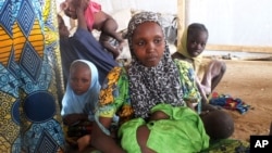 FILE - A family of refugees that fled their homes due to violence from the Islamic extremist group Boko Haram sit inside a refugee camp in Minawao, Cameroon, Feb. 25, 2015.