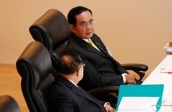 FILE - Thailand's Prime Minister Prayuth Chan-ocha, top, talks to Deputy Prime Minister Prawit Wongsuwan during the special session at the parliament in Bangkok, Thailand, Oct. 26, 2020.