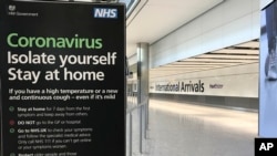 A sign at Heathrow Airport Terminal 5 arrivals warns of Coronavirus, in London, March 24, 2020. 