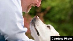 Seorang pria AS bermain dengan anjingnya (foto: ilustrasi). 