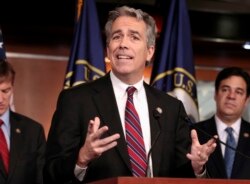 FILE - Former U.S. Rep. Joe Walsh, R-Ill., gestures during a news conference on Capitol Hill in Washington.
