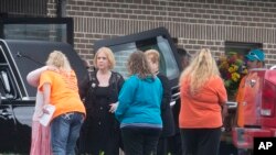Caskets are loaded into hearses as mourners gather outside Dry Run Church of Christ during funeral services for six of the eight murder victims from Pike County, Tuesday, May 3, 2016.