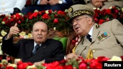 FILE - Algeria's President Abdelaziz Bouteflika gestures while talking with Army Chief of Staff Lt. Gen. Ahmed Gaed Salah during a graduation ceremony of the 40th class of the trainee army officers at a military academy in Cherchell, west of Algiers, Algeria, June 27, 2012.