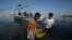 FILE - Filipino fishermen bring their fish to shore in the coastal town of Infanta, Pangasinan province, northwestern Philippines. 