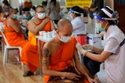 FILE - Health workers administer doses of the AstraZeneca COVID-19 vaccine to Buddhist monks at the Wat Srisudaram in Bangkok, Thailand, July 30, 2021. (AP Photo/Sakchai Lalit)