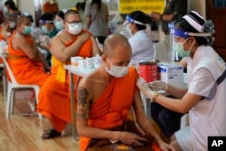 FILE - Health workers administer doses of the AstraZeneca COVID-19 vaccine to Buddhist monks at the Wat Srisudaram in Bangkok, Thailand, July 30, 2021. (AP Photo/Sakchai Lalit)