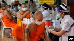 Health workers administer doses of the AstraZeneca COVID-19 vaccine to Buddhist monks at the Wat Srisudaram in Bangkok, Thailand, July 30, 2021.