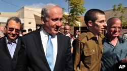 (de g. à dr.) Ehud Barak, Benjamin Netanyahu, Gilad Shalit et son père Noam (Base aérienne Tel Nof, sud d'Israël, 18 oct. 2011)