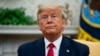 FILE - President Donald Trump listens to a question from a reporter, in the Oval Office of the White House, in Washington, Feb. 12, 2020. 