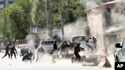 Security forces run from the site of a suicide attack after the second bombing in Kabul, Afghanistan, Monday, April 30, 2018. 