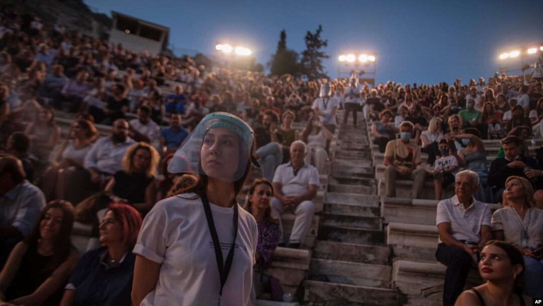 Una acomodadora con una pantalla facial se ve delante del público en el anfiteatro Odeón de Herodes Ático, en Atenas, Grecia, el 15 de julio de 2020, cuando se reiniciaron las presentaciones..