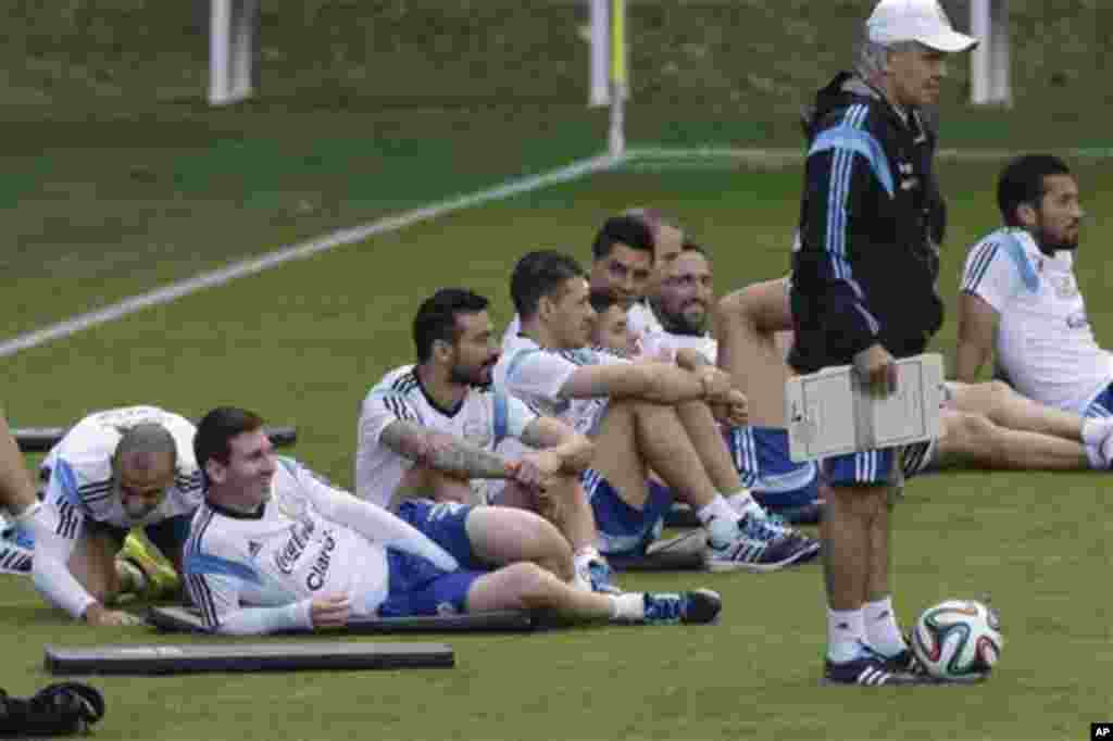 Argentina's Javier Mascherano, left, and Lionel Messi, second left, sit with teammates next to Argentina's head coach Alejandro Sabella, right, during a training session in Vespesiano, near Belo Horizonte, Brazil, Thursday, July 10, 2014. On Sunday, Argen