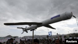 资料照片：在也门首都萨那，示威者在声援加上巴勒斯坦人的集会上举着模拟无人机。(2024年2月16日)