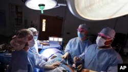  Dr. Keith Melancon, right, Georgetown's kidney transplant director, performs the surgery to harvest the kidney from a donor in Washington.