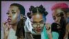 FILE—Men wearing face masks walk past a hair product billboard on the street in Soweto, South Africa, June 29, 2020.