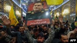 People lift a portrait of Iran's Islamic Revolutionary Guards Corps' slain commander Abbas Nilforushan during his funeral procession at the Imam Hussein shrine in Iraq's holy central city of Karbala, Oct. 14, 2024.