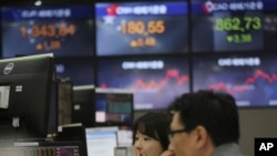 Currency traders watch monitors at the foreign exchange dealing room of the KEB Hana Bank headquarters in Seoul, South Korea, March 13, 2020.