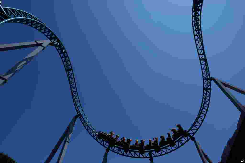 Visitors enjoy a ride on a roller coaster at Cinecitta World amusement park in the outskirts of Rome, Italy, on the day of its reopening.