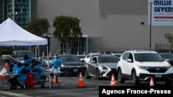 Vehicles wait in line to receive Covid-19 PCR tests at a Long Beach Public Health Department testing site in the parking lot of a former Boeing aircraft factory on Jan. 10, 2022 in Long Beach, California. 