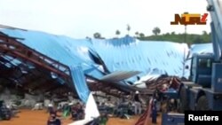 Orang-orang berdiri dekat gereja yang runtuh di tengah berlangsungnya kebaktian di kota Uyo, negara bagian Akwa Ibom, Nigeria, Sabtu, 10 Desember 2016.