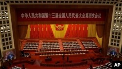 With screens showing Chinese President Xi Jinping, delegates attend the opening session of China's National People's Congress (NPC) at the Great Hall of the People in Beijing on March 5, 2021. 
