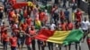 Des Guinéens avec leur drapeau national manifestent pacifiquement contre le troisième mandat du président guinéen, le 7 novembre 2019 à Conakry. (Photo par CELLOU BINANI / AFP) 