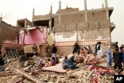 Locals inspect the site of a car bomb attack in Herat province, west of Kabul, Afghanistan, March 13, 2021.