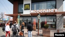 Warga berkumpul di luar salah satu restoran McDonald's di Simferopol, Krimea (4/4). Restoran cepat saji ini menutup operasi tiga gerainya di wilayah Krimea.