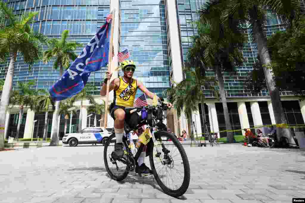 Un partidario del expresidente de los Estados Unidos, Donald Trump, anda en bicicleta cerca del Palacio de Justicia mostrando su apoyo al republicano.