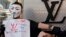 A protester wearing a Guy Fawkes mask demonstrates outside a Louis Vuitton store at Hong Kong's Tsim Sha Tsui shopping district, Mar. 10, 2013. 