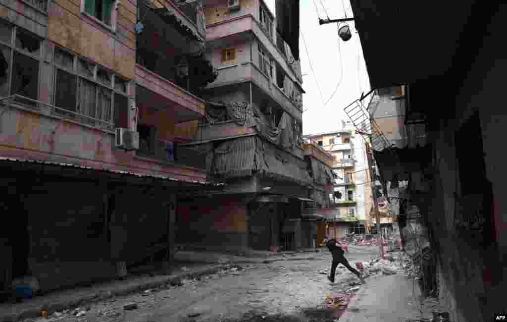 A Syrian rebel fighter runs to avoid snipers of government forces in the Saladin district of Aleppo, April 8, 2013.