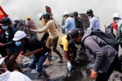 Gas air mata dan gas pemadam kebakaran mengelilingi para demonstran saat mereka melarikan diri dari polisi saat melakukan protes terhadap kudeta militer di Naypyitaw, Myanmar, 8 Maret 2021. (Foto: Reuters)