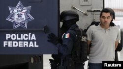 La policía federal mexicana escolta a Bogard Lugo (derecha), acusado de ser uno de los causantes de la balacera en el aeropuerto de la Ciudad de México.