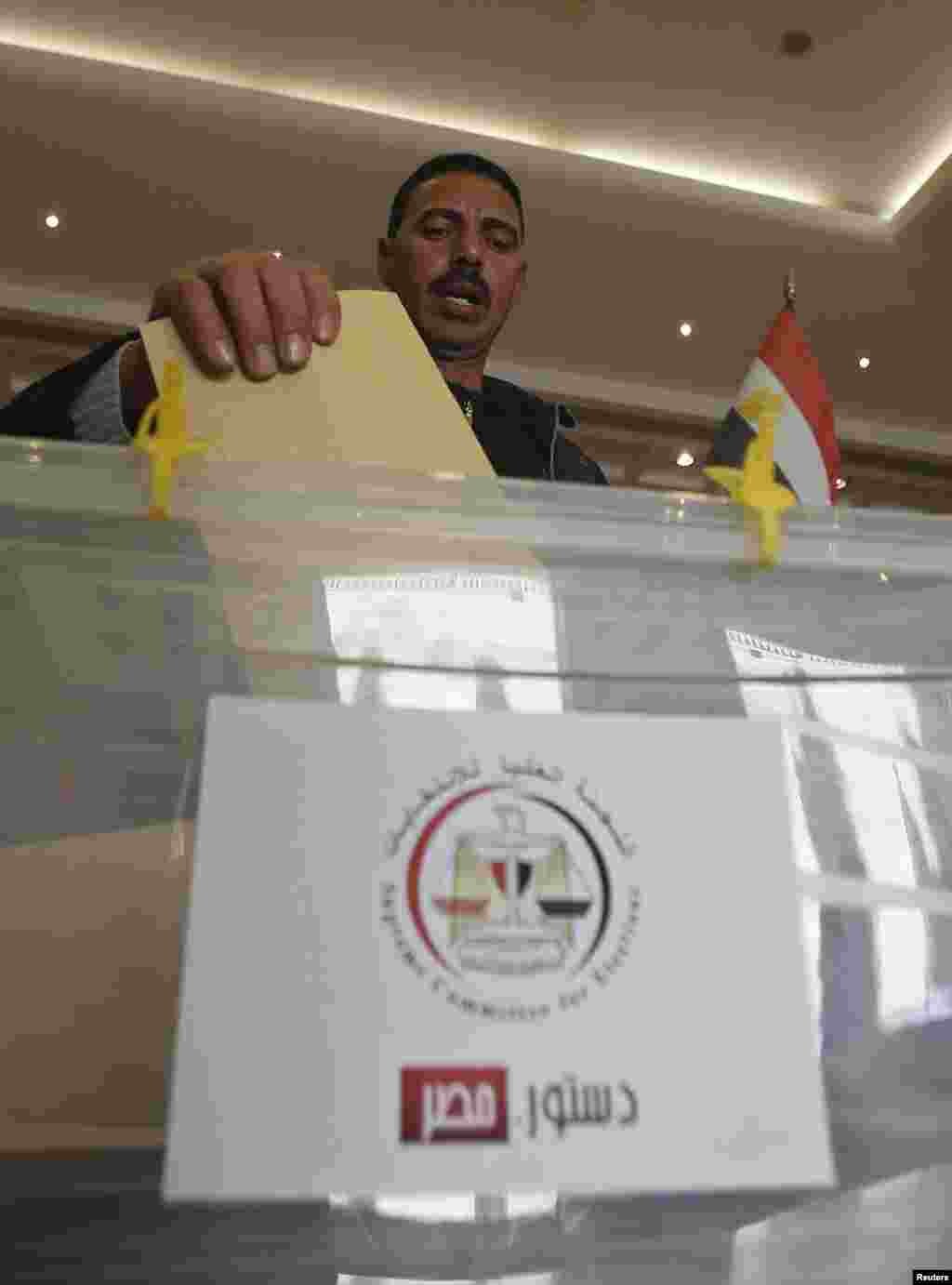 An Egyptian votes on the new Egyptian constitution at the Egyptian embassy in Amman December 12. 