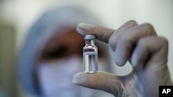 Una trabajadora muestra un vial de la vacuna contra el coronavirus desarrollada por AstraZeneca y la Universidad de Oxford, y producida por la Fundación Fiocruz en Río de Janeiro, Brasil, el 12 de febrero de 2021.