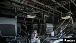 Работники супермаркета, поврежденного в результате российского ракетного удара, наводят порядок в помещении. Днепр, 1 июля 2024 г. 
