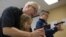 FILE - Instructor Jerry Kau shows student Joanna Zuber how to load a magazine into a handgun alongside Sam Minnifield during a Youth Handgun Safety Class at GAT Guns in East Dundee, Illinois, April 21, 2015.