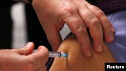 FILE - A woman receives a vaccination in this 2009 file photo. Researchers say a vaccine for chlamydia — the world's most common sexually transmitted disease — is showing promise.