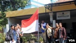 Koalisi Masyarakat Sipil Peduli Kedaulatan Rakyat Jawa Timur mengiibarkan bendera Merah Putih setengah tiang atas pengesahan UU Pilkada oleh DPR, yang mengembalikan pemilihan langsung oleh rakyat kepada DPRD, 26 September 2014 (Foto: VOA/Petrus)