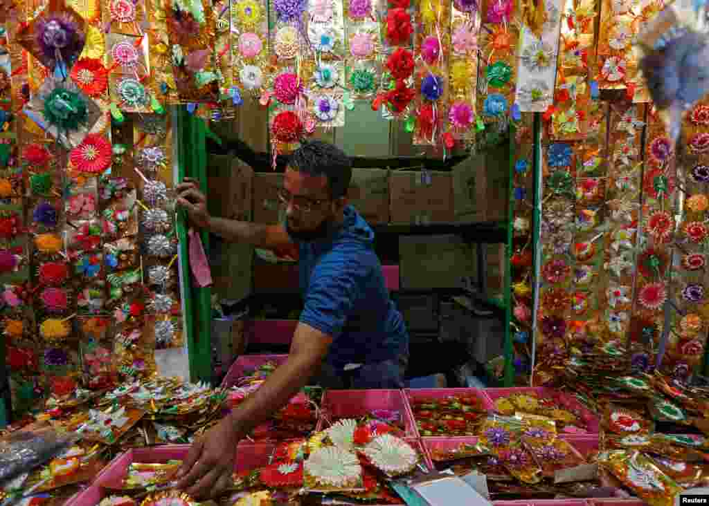 A man arranges "Rakhis" or sacred threads as he waits for customers at his roadside stall ahead of the Hindu festival Raksha Bandhan celebrations, in Kolkata, India.