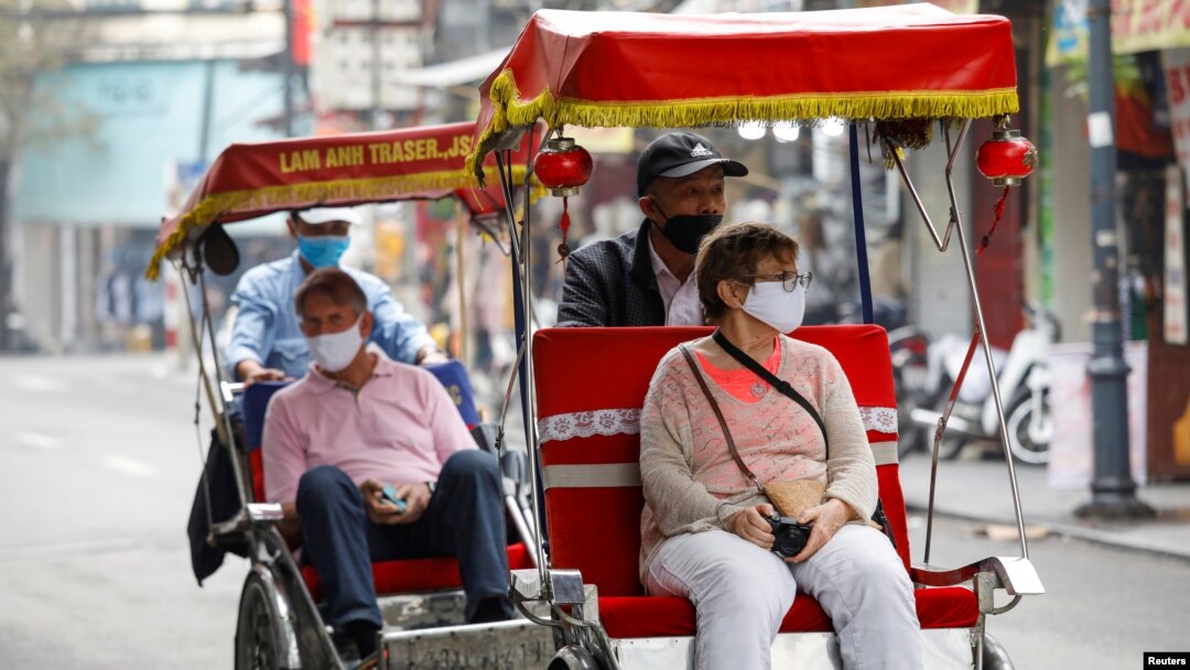 Khách nước ngoài đi tham quan bằng xích lô tại Việt Nam. Công an Việt Nam nói số lượng lớn người nước ngoài đang lưu trú tại TPHCM gây áp lực cho công tác quản lý cư trú người nước ngoài của họ.