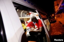 FILE - Medics examine a pregnant woman in an ambulance during the coronavirus night curfew in Nairobi, Kenya, June 19, 2020.