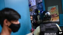 Miembros de la policía nacional ordenan al dueño de un negocio cerrar su tienda durante una cuarentena ordenado por el gobierno para frenar la propagación de COVID-19 en Caracas, el 21 de mayo de 2021.