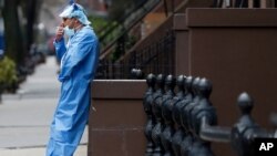Wearing his personal protective equipment, emergency room nurse Brian Stephen leans against a stoop as he takes a break from his work at the Brooklyn Hospital Center in New York, April 5, 2020.
