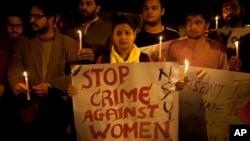 FILE - Indian youth hold candles during a protest against sexual violence in New Delhi, India, Feb. 9, 2015.