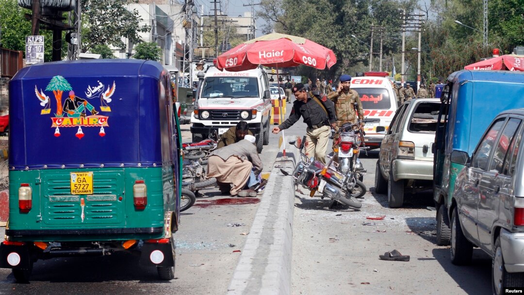 Para petugas keamanan setempat memeriksa lokasi serangan bom di Peshawar, Pakistan (29/3).