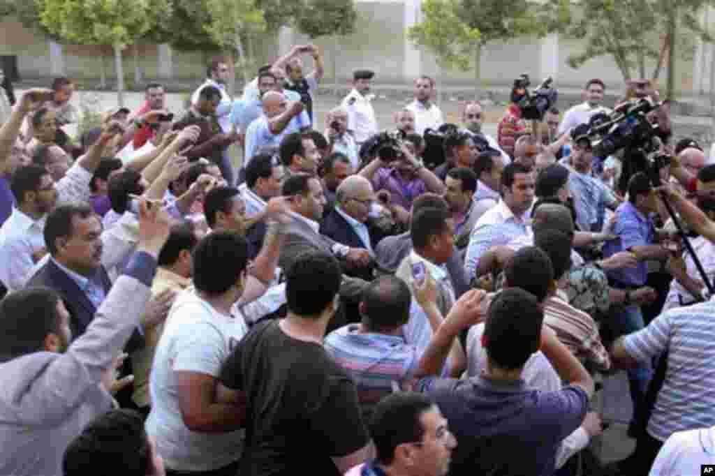 Egyptian presidential candidate Ahmed Shafiq, center, arrives to vote at a polling site in Cairo, Egypt, Wednesday, May 23, 2012. Presidential Candidate and former Egyptian Prime Minister Ahmed Shafiq was met by scores of protesters as he arrived to cast 