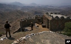 FILE - Pasukan Angkatan Darat Pakistan mengamati kawqasan sekitarnya dari pos puncak bukit di Pakistan Afghanistan, di distrik Khyber, Pakistan, 3 Agustus 2021. (AP/Anjum Naveed, File)