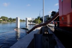 FILE - A pumping station is set up along the Intracoastal Waterway to prevent flooding during a king tide, Sept. 28, 2019, in Miami Beach, Fla. Low-lying neighborhoods in South Florida are vulnerable to seasonal flooding caused by king tides.