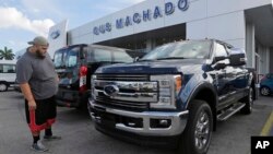 FILE - A potential customer looks at a Ford F-250 Lariat FX4 at a Ford dealership, in Hialeah, Florida, Jan. 17, 2017.